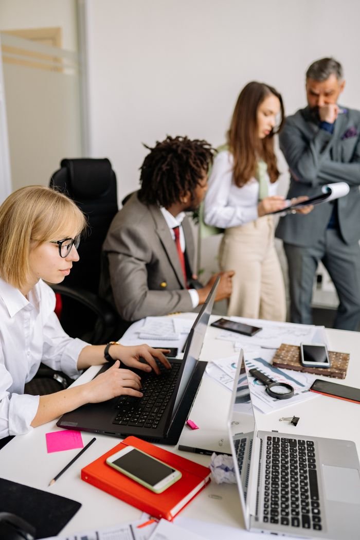 Business professionals engaged in teamwork and discussion in a modern office setting.